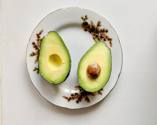 Sliced fresh avocado showing its green interior on a rustic plate